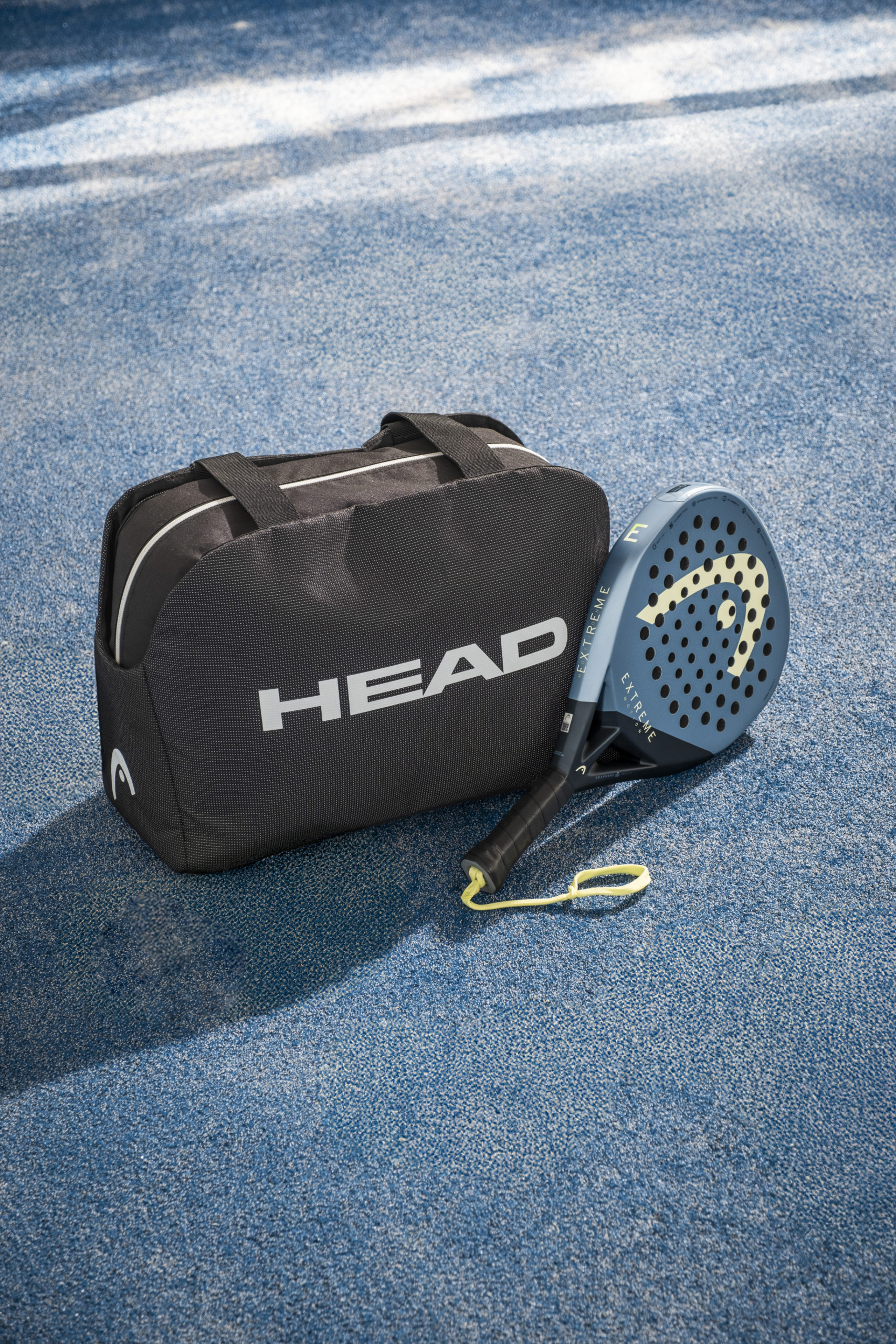 Product shot sac et raquette sur un terrain de padel
